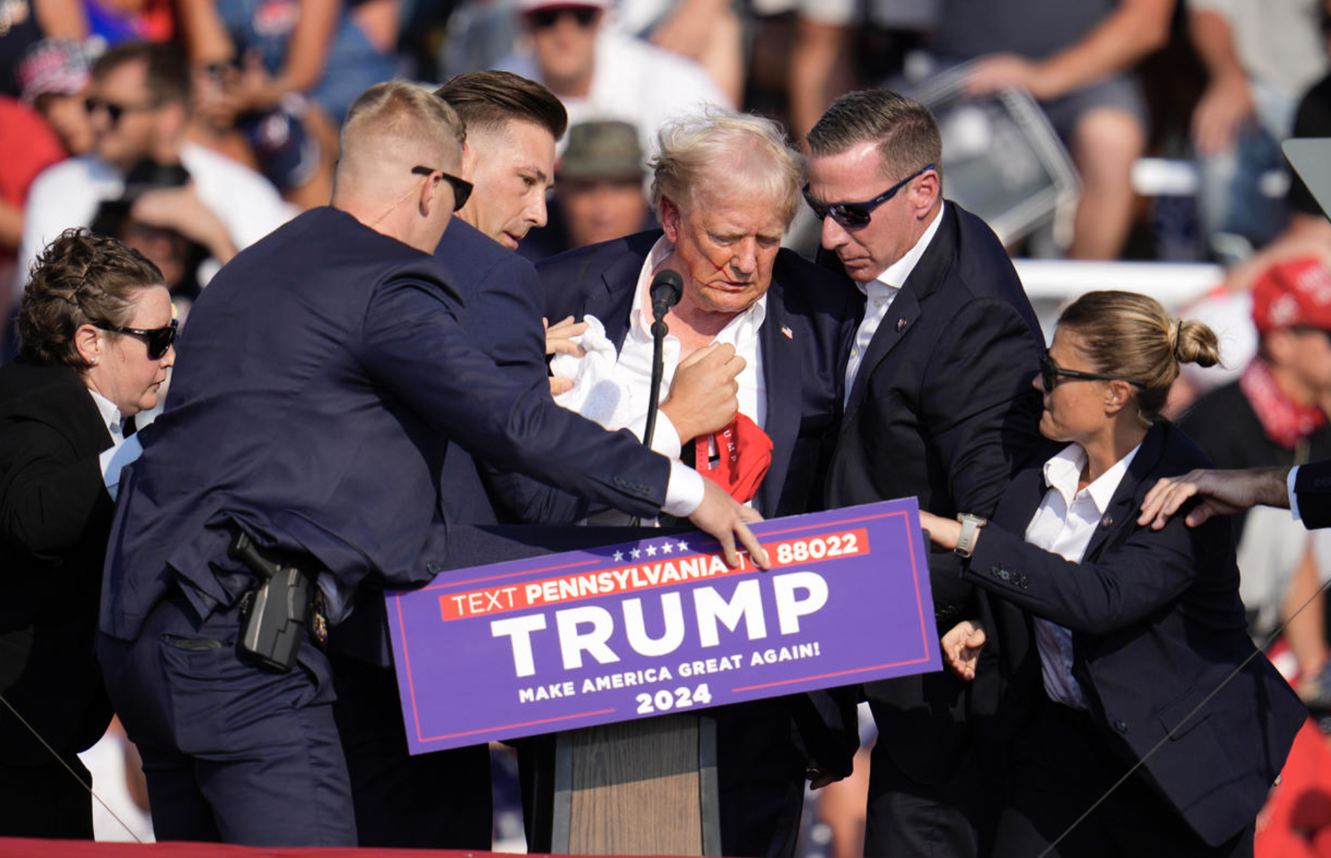 Donald Trump surrounded by secret service on stage