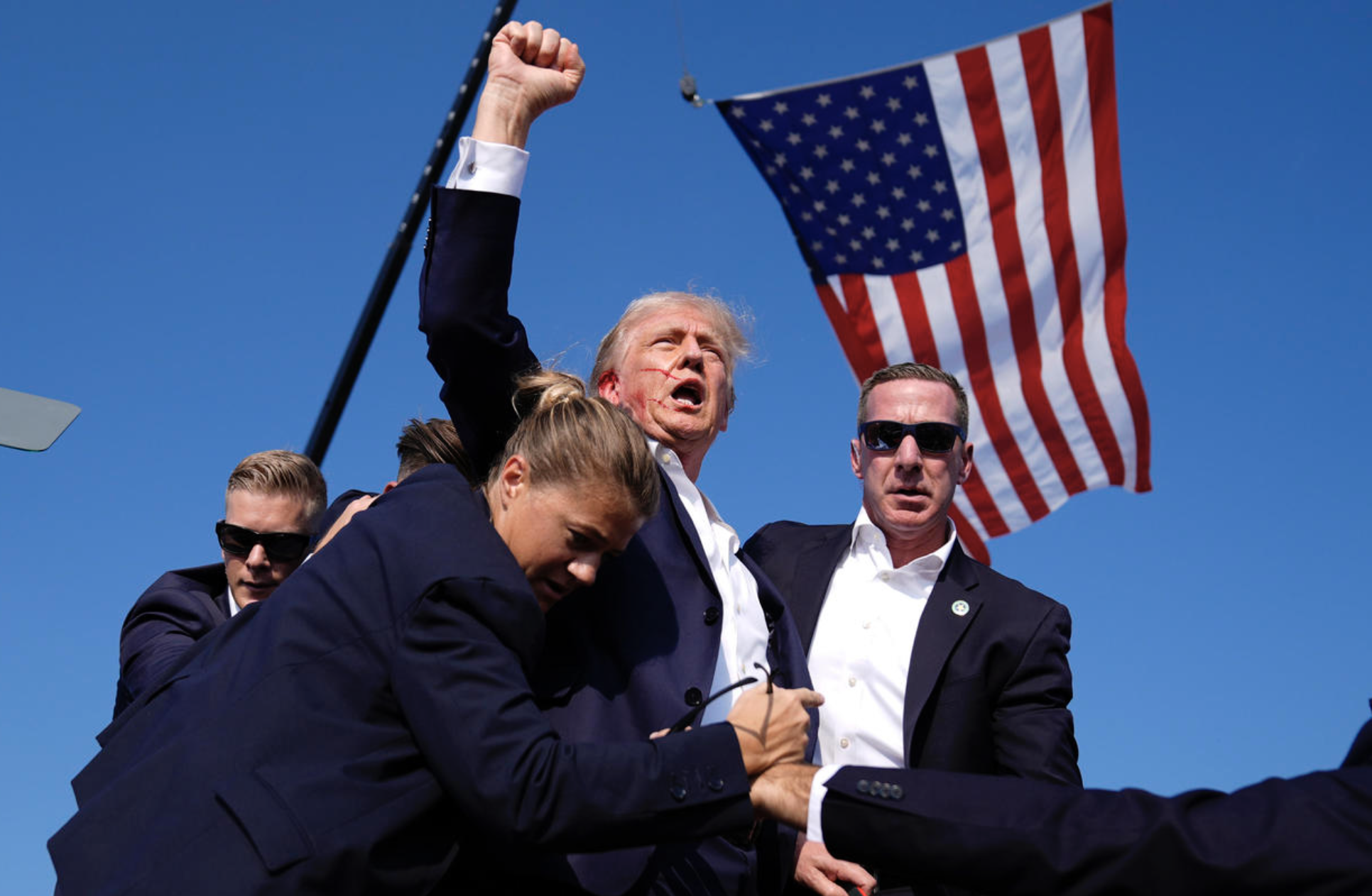 Former President Donald Trump is surrounded by U.S. Secret Service agents after apparent shots were fired at his campaign rally, July 13, 2024, in Butler, Pa.