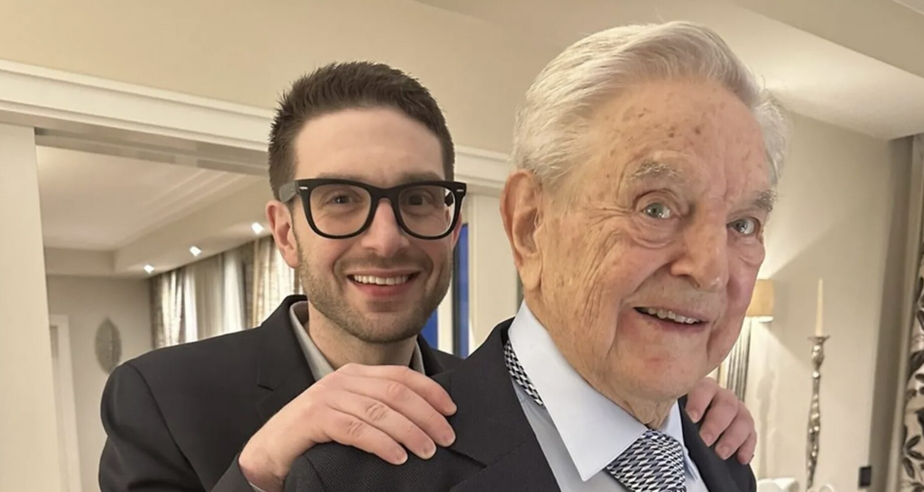US billionaire philanthropist George Soros has handed over the running of his $25bn (£19.9bn) financial and charitable empire to his son Alex.